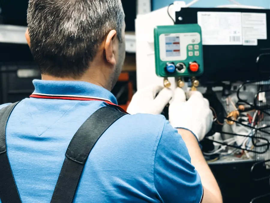 Technician performing air conditioning maintenance