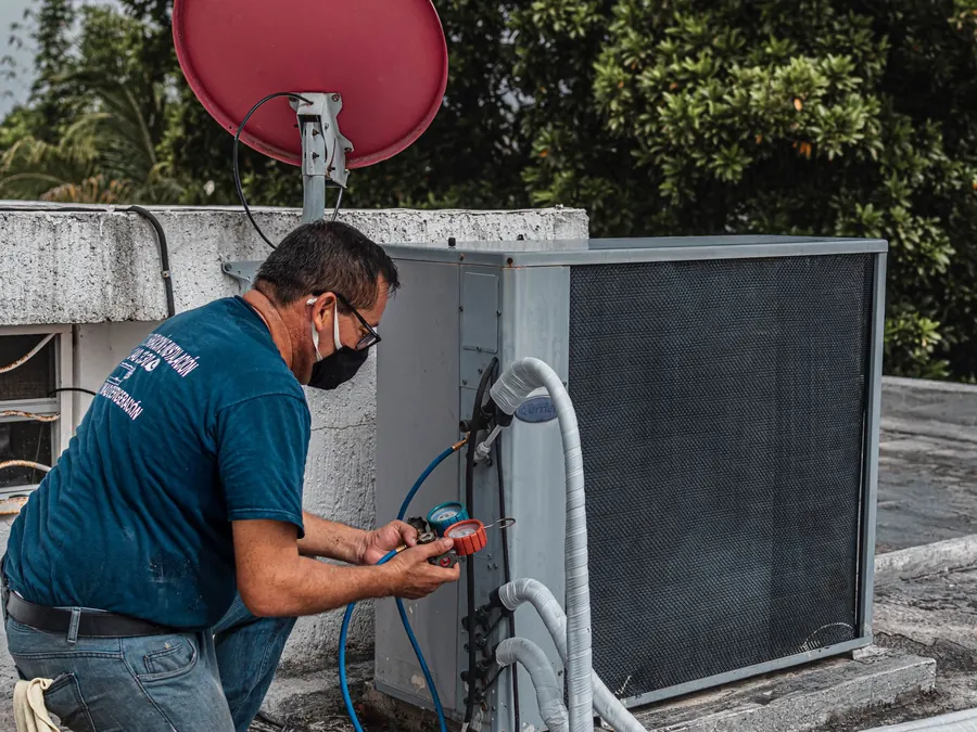 Technician checking an outdoor AC condenser